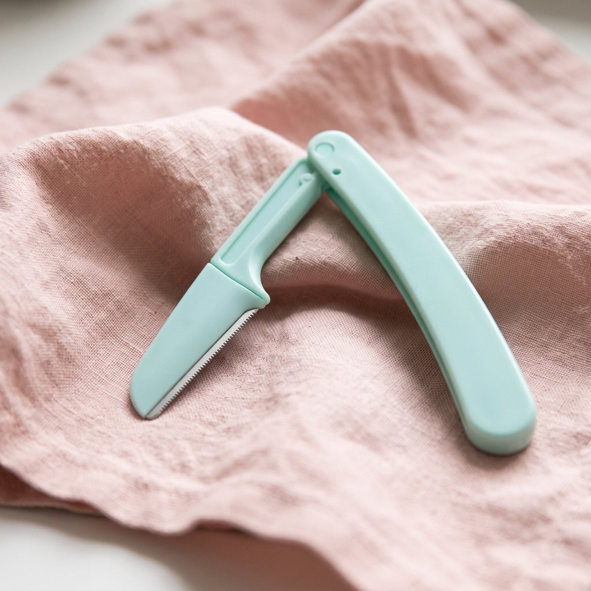 Mint folding face razor half open, showing the blade guard